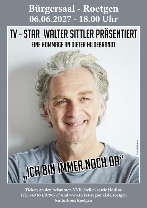 The image shows a smiling man with gray hair looking at the camera. He is presenting an event that is a tribute to Dieter Hildebrandt.