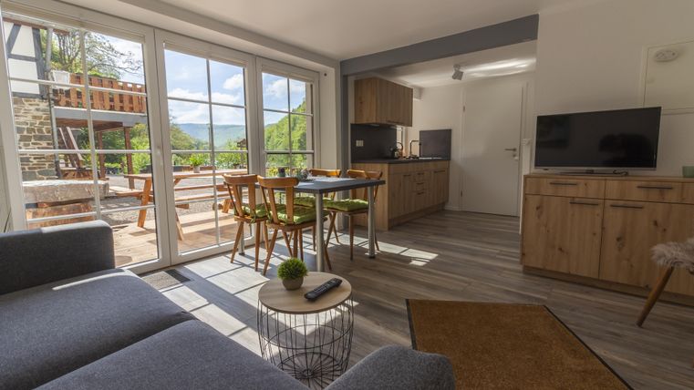 Eine moderne Wohnung mit einem gemütlichen Wohnbereich und viel natürlichem Licht. Die Küche ist hell und einladend, mit Blick auf die Terrasse.