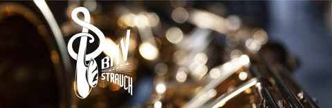 Ein verschwommenes Bild eines Instruments mit goldenen Details im Vordergrund. Im oberen linken Bereich steht ein Logo.