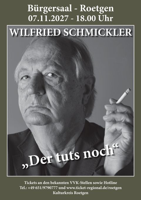 A black-and-white portrait of Wilfried Schmickler. He looks seriously into the camera and holds his hand in a striking manner.