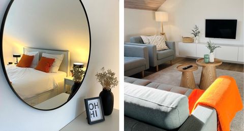 Ein stilvolles Schlafzimmer mit einem großen Spiegel und einem bequemen Bett. Im Wohnzimmer befinden sich moderne Möbel und dekorative Elemente.