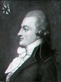 Portrait d'un homme de profil, aux cheveux soigneusement coiffés et vêtu d'un costume élégant. Il porte une cravate nouée en boucle et arbore un air pensif.
