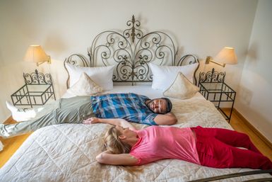 Zwei Personen liegen quer auf einem Bett
