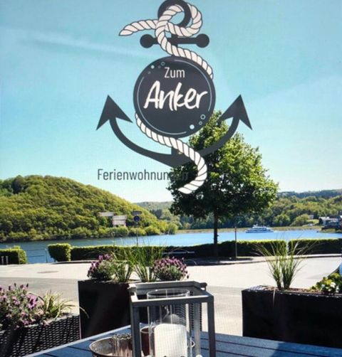 Eine moderne Wohnung mit einer offenen Küche und einem gemütlichen Wohnbereich. Die Möbel sind in neutralen Farben gehalten, mit zwei kleinen Tischen in der Mitte.