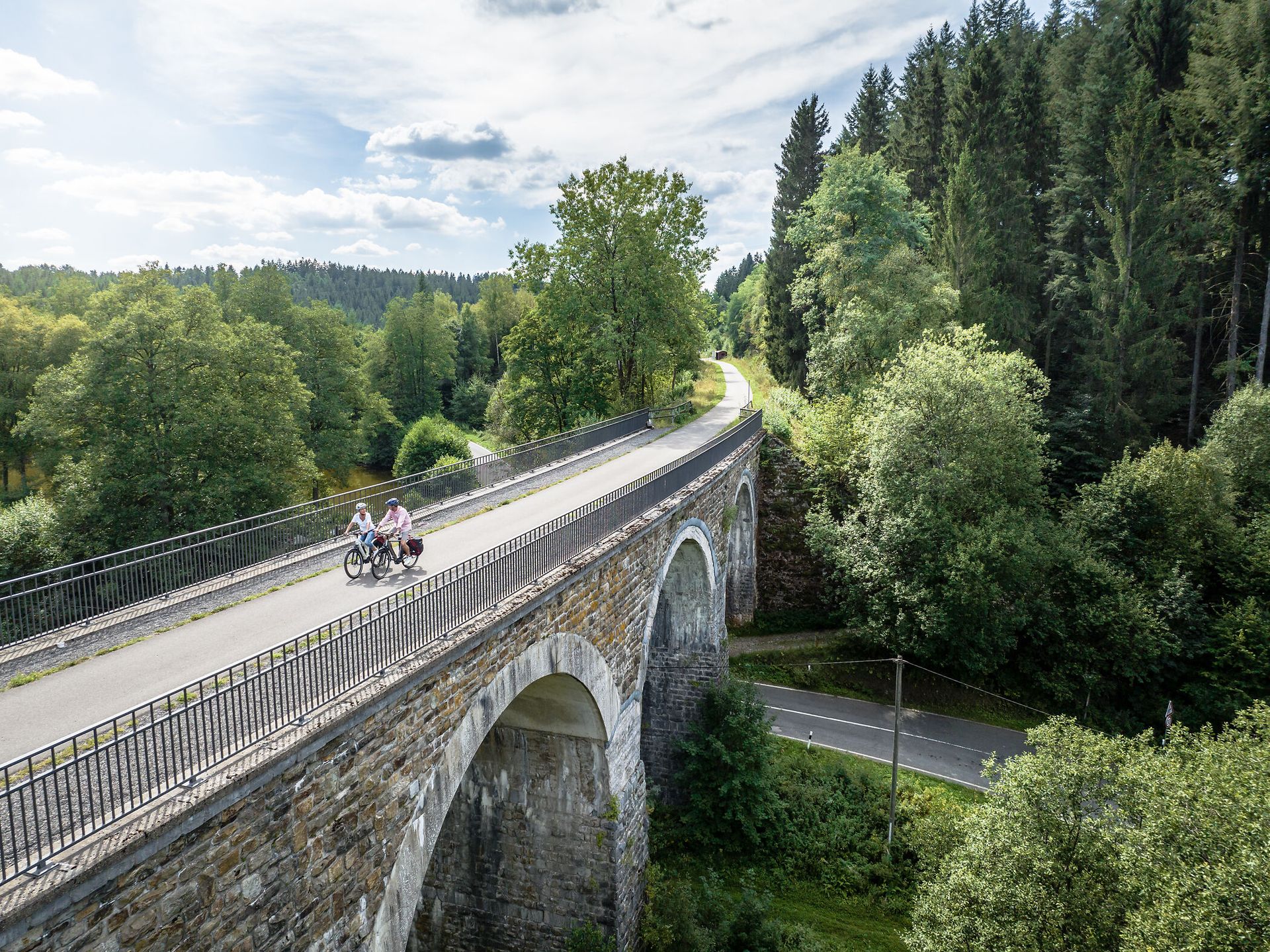 Auf dem Bild fahren zwei Personen über das Viadukt in Reichenstein mit dem Fahrrad