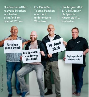 Eine Gruppe von vier Männern hält Schilder mit Informationen über eine Spendenwanderung. Die Veranstaltung findet am 19. April 2026 statt und dient einem guten Zweck.