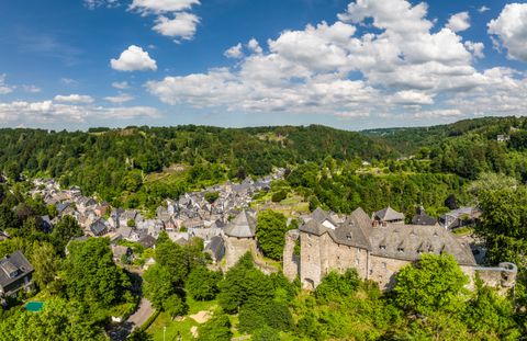 Vue panoramique de Monschau avec son château et son paysage verdoyant.