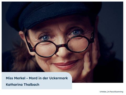 Ein Porträt von Katharina Thalbach in einem Hut mit Brille. Sie lächelt freundlich in die Kamera.