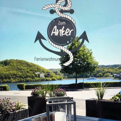 Een moderne woning met een open keuken en een gezellige woonkamer. De meubels zijn in neutrale kleuren, met twee kleine tafels in het midden.