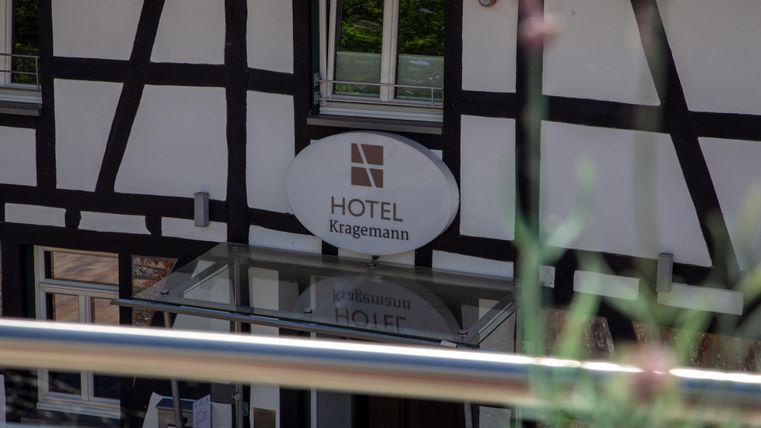 Ein Hotel mit einem klassischen Fachwerkstil und einem modernen Schild. Der Eingang ist gut sichtbar und einladend.