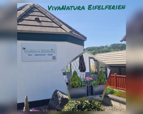 Ein charmantes Ferienhaus mit dem Namen "VivaNatura Eifelferien". Das Schild zeigt die Unterkunft in einer schönen Umgebung.