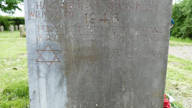 Une stèle commémorative en pierre portant des inscriptions datant de 1946. L'étoile de David y est visible, en souvenir de l'Holocauste.