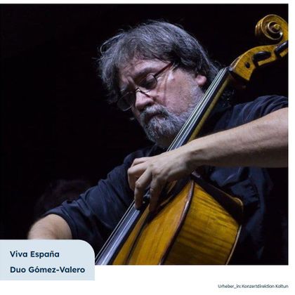 Ein Musiker spielt Cello auf der Bühne. Das Bild zeigt konzentrierte Musikalität und einen melancholischen Ausdruck.