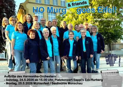 Een groep mensen staat glimlachend buiten, gekleed in blauwe T-shirts. Ze maken deel uit van het harmonicaorkest en kijken uit naar hun optredens in de Eifel.