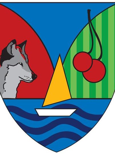 Ein Wappen mit einem Wolf, einem Segelboot auf Wasser und Kirschen auf gestreiftem Hintergrund. Die Farben Rot, Blau und Grün prägen das Design.