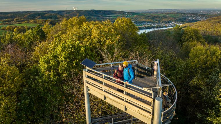 Der oberere Teil des Krawutschketurm auf dem zwei Menschen stehen ist zu sehen. Im Hintergrund ist ein dichter Wald