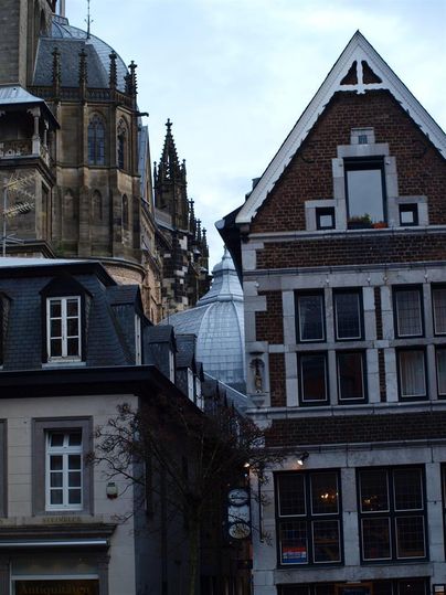 Een stadsbeeld met oude gebouwen en een modern dak. De architectuur toont een mix van historische en hedendaagse stijlen.