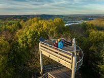 Der oberere Teil des Krawutschketurm auf dem zwei Menschen stehen ist zu sehen. Im Hintergrund ist ein dichter Wald