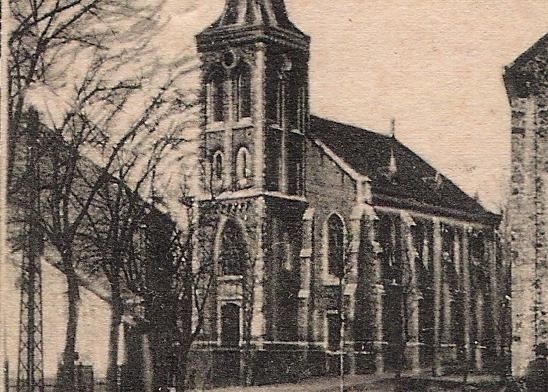 Une vieille église avec un haut clocher et des arbres au premier plan. L'architecture est sobre et construite en pierre.
