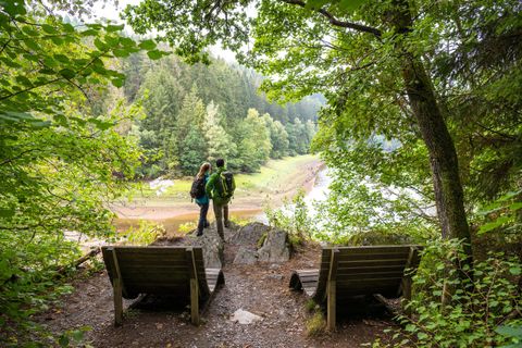 2 Personen schauen auf den aufgestauten Perlenbach